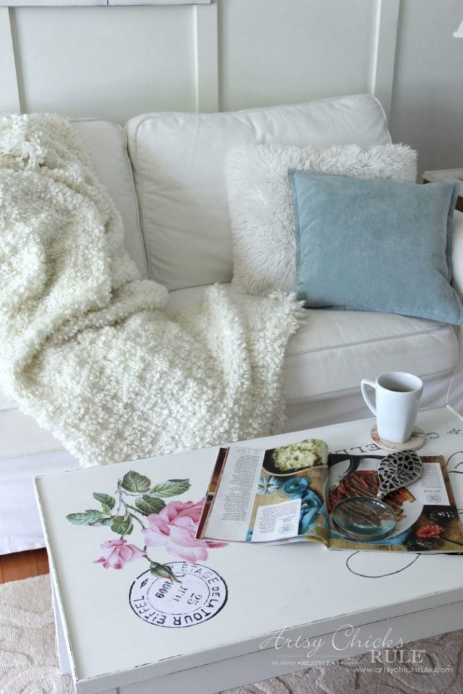cozy couch with blanket and pillows, coffee mug and magazine on table