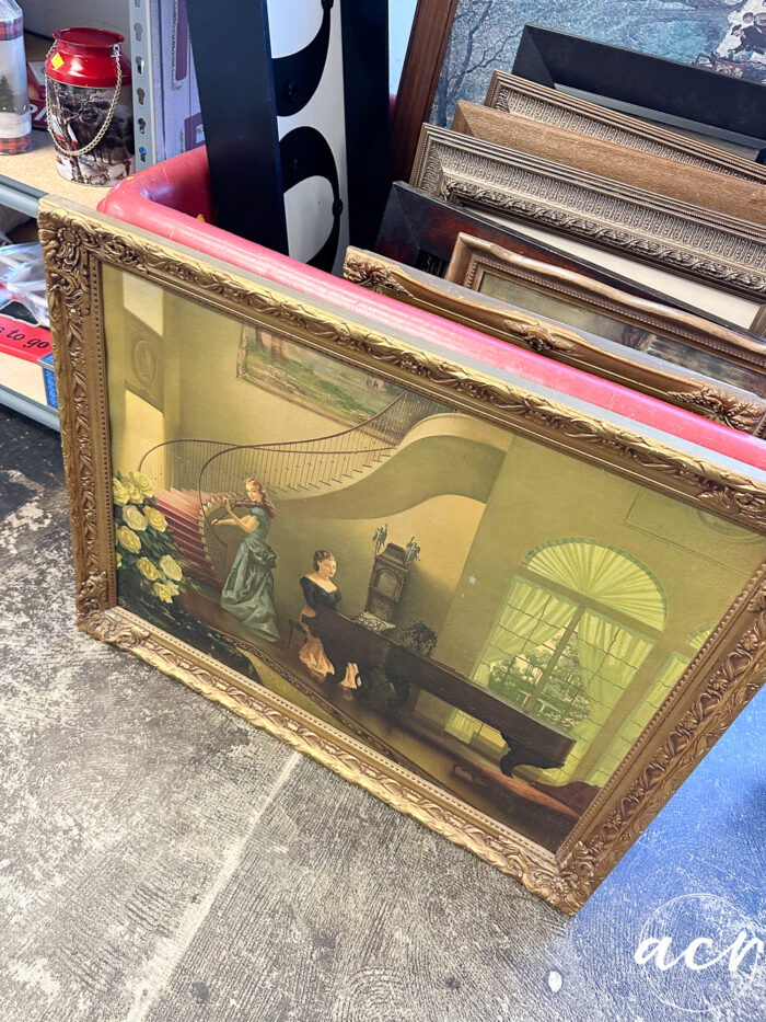 old gold frame print of girl playing piano and girl playing violin