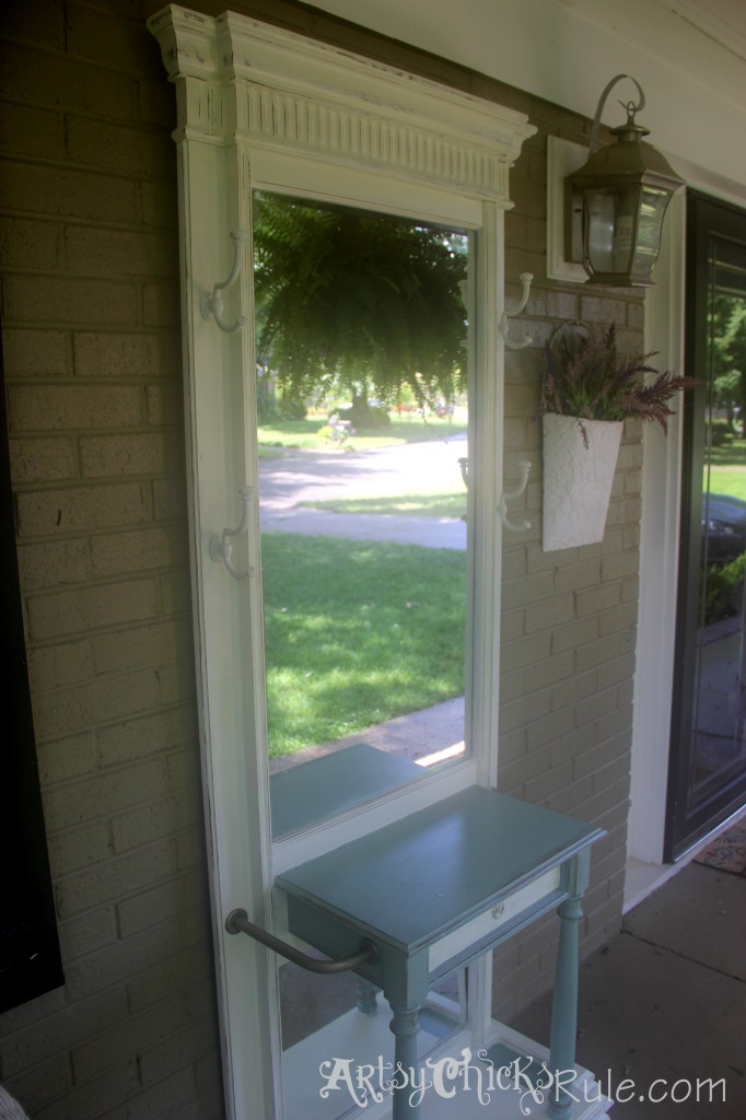 hall tree on porch with white basket and flowers hanging beside