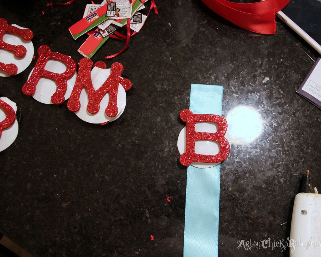 Hot glue letter to shell, shell to ribbon