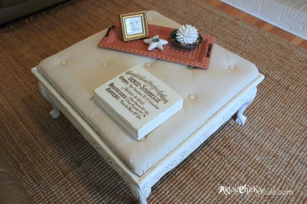 decorated tufted ottoman on rug