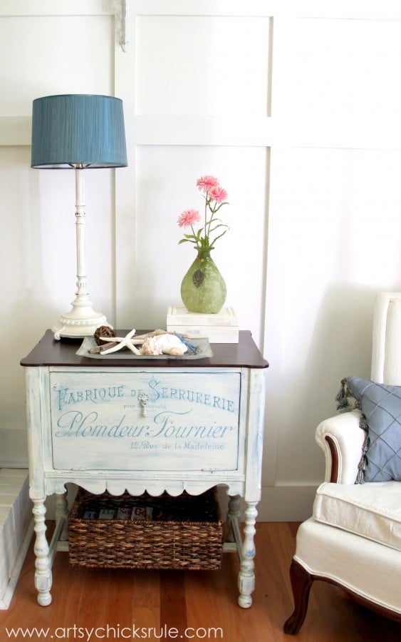 French writing on front of white cabinet with blue lamp on top