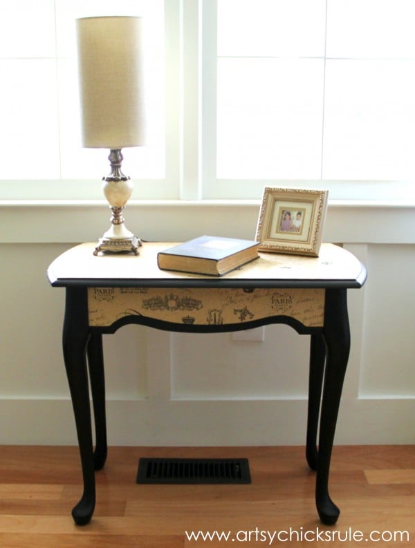 small black table with lamp and book