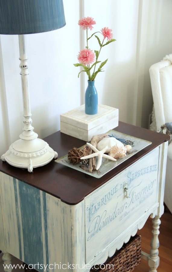 blue and white french cabinet with blue lamp on top and pink flowers