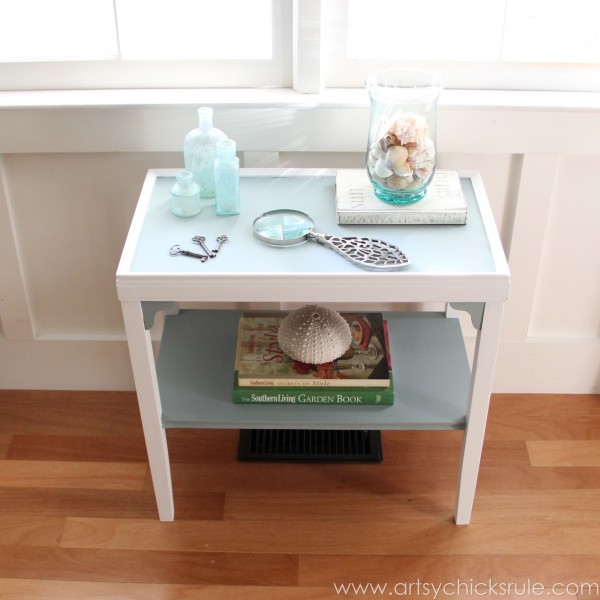 two tone side table by window with decor styled