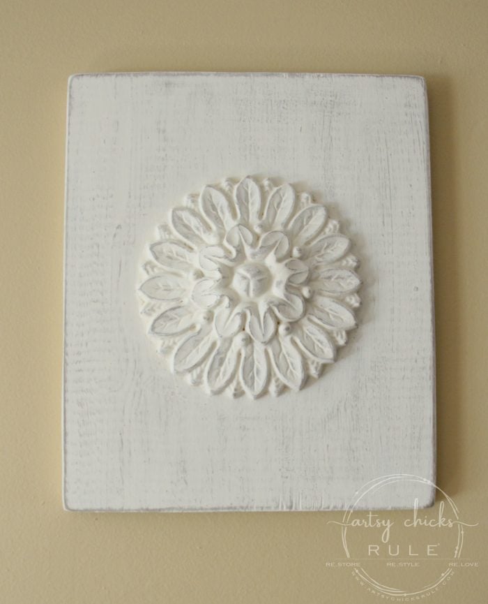 creamy white wood medallion on yellow wall