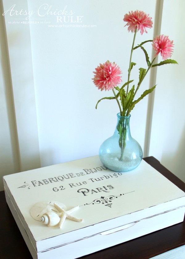 white box with French writing and blue vase