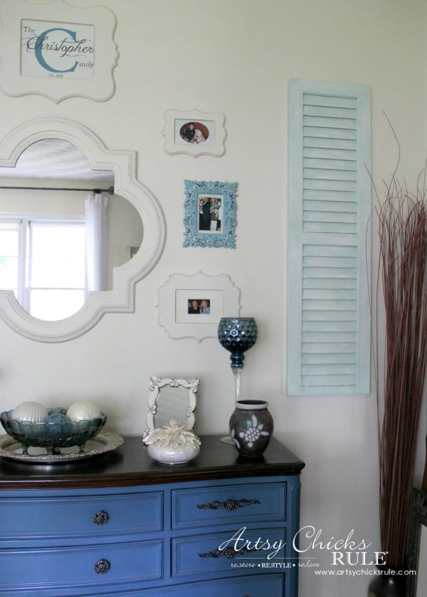 gallery wall with mirror with blue dresser