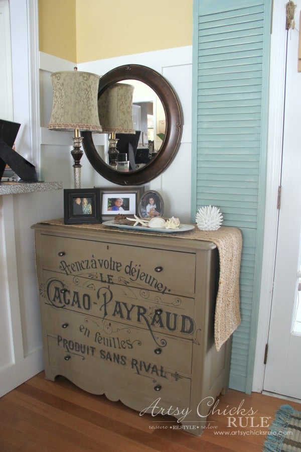 tan dresser with french black graphic painted on front