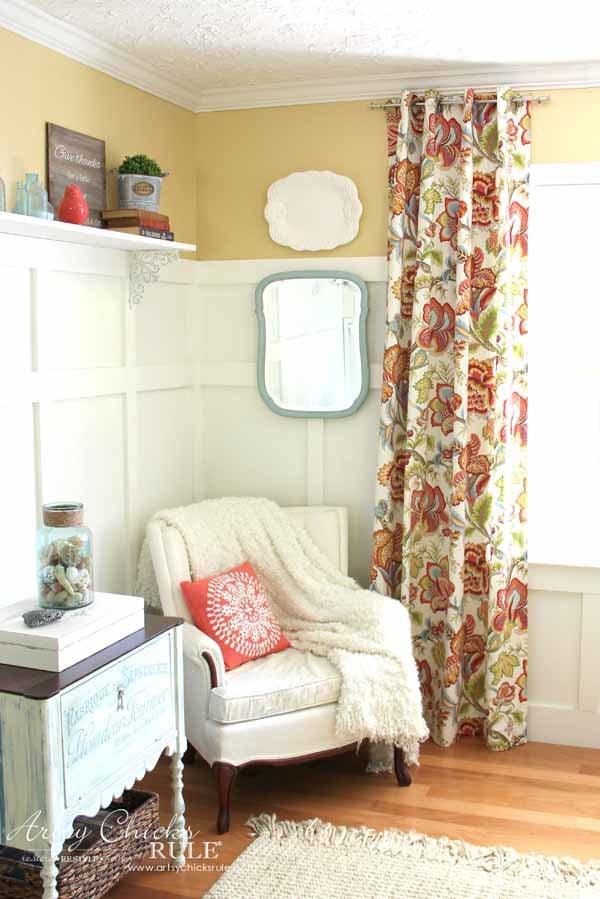 yellow walls, white chair and colorful curtains