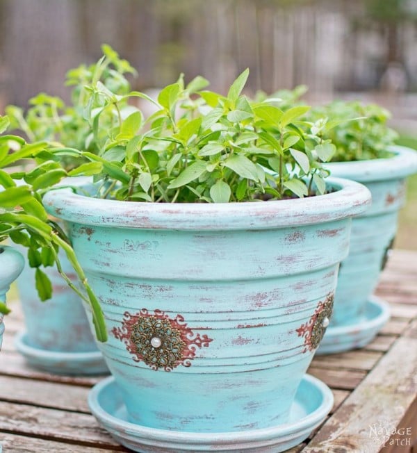 An old flower pot painted and with a stencil on it.