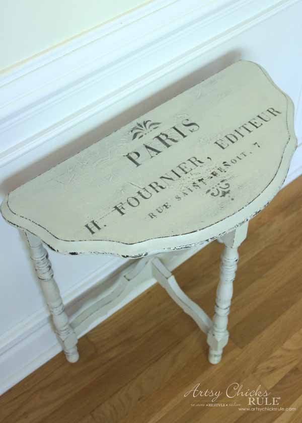 cream colored half moon table with french graphic