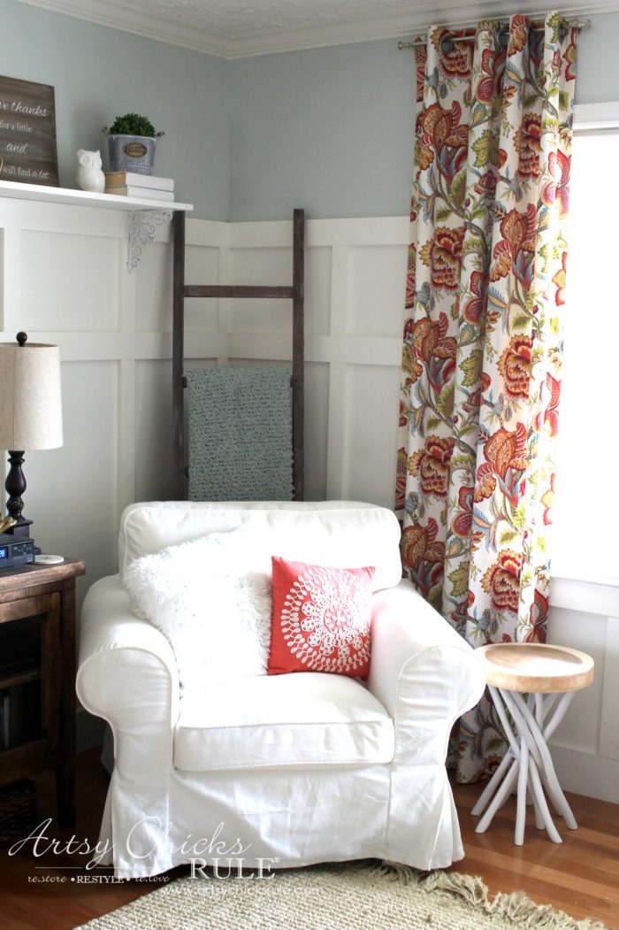 white chair with colorful curtain and ladder behind chair