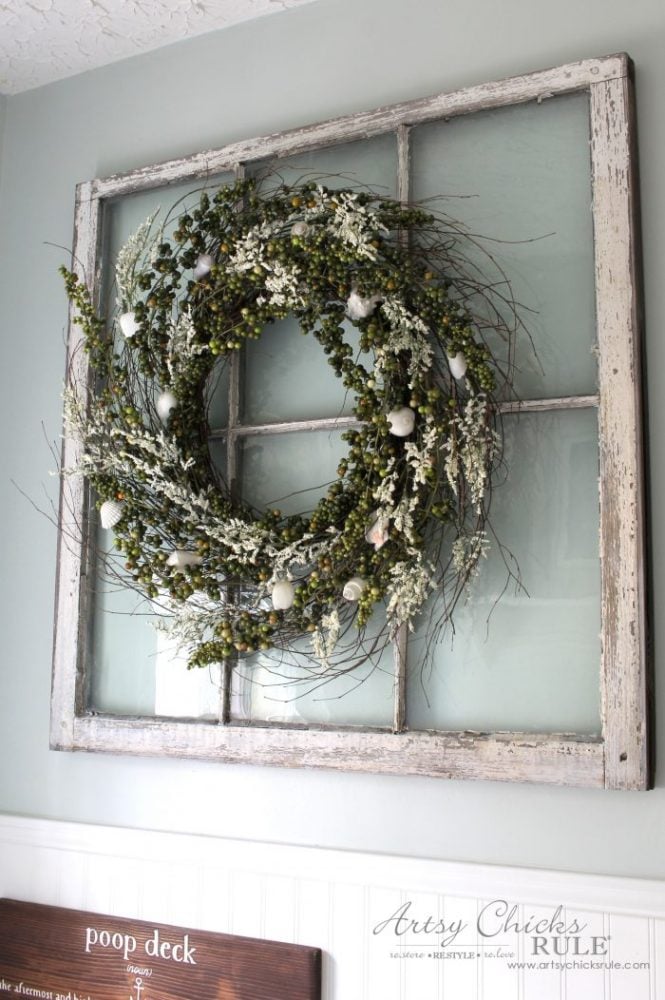 green and white wreath hanging on very old window