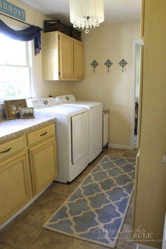 laundry room with gold painted cabinets blue rug