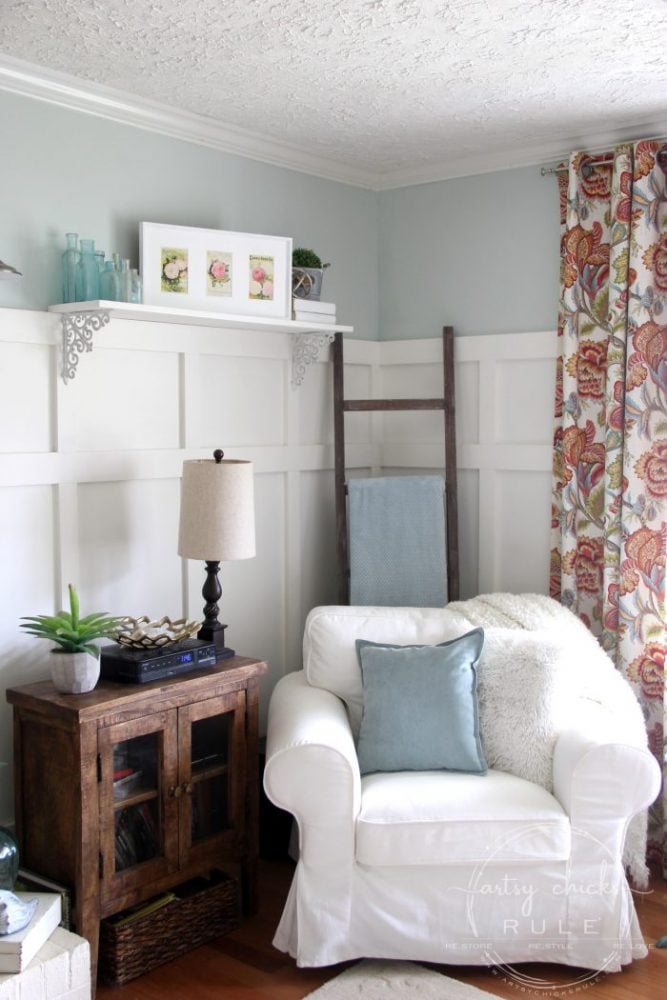 white chair with colorful curtains and white wood wall treatment