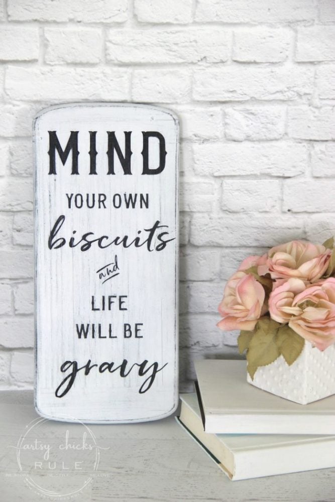 white kitchen sign with funny saying, mind your own biscuits and life will be gravy