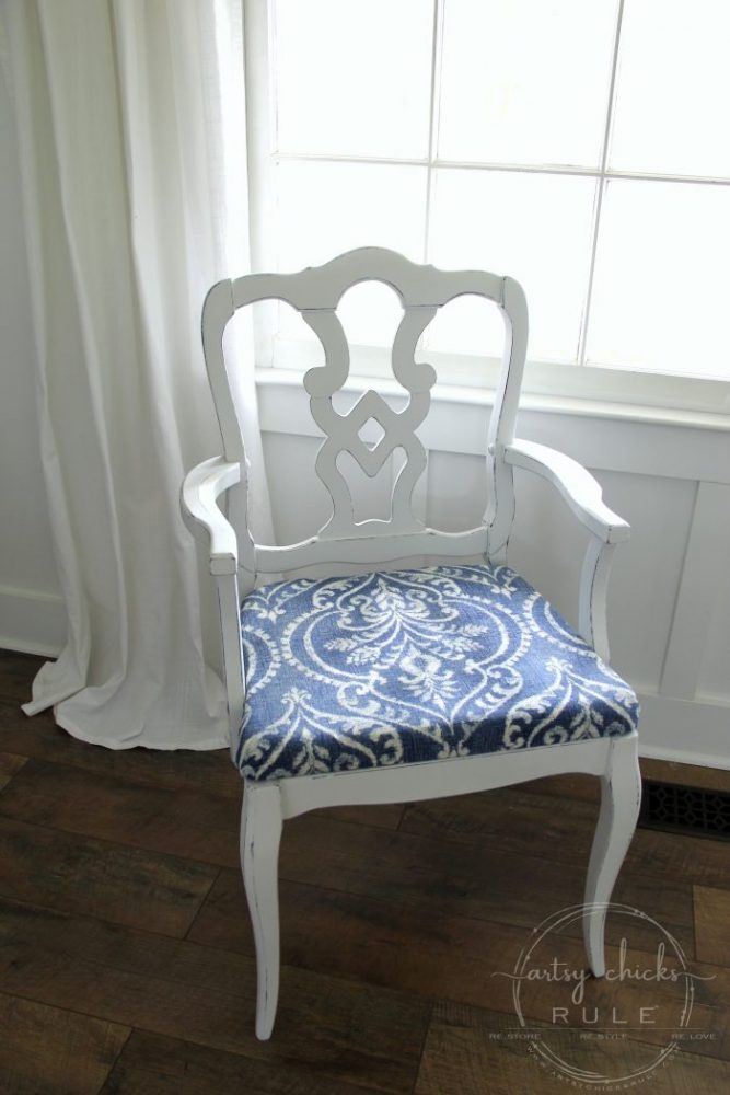 white chair with blue seat and white curtain behind