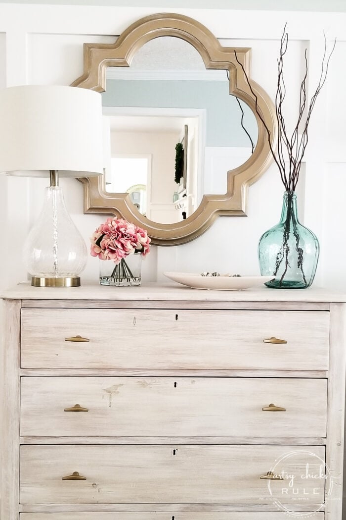 off white dresser with gold hardware with gold mirror over