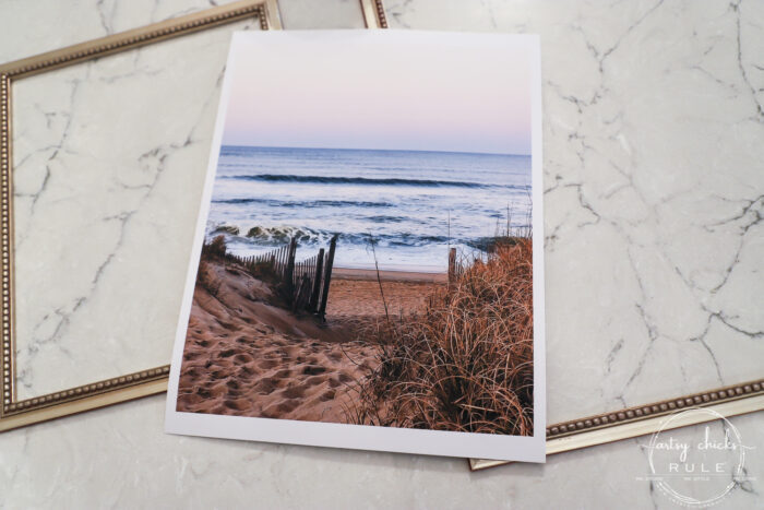 This beach scene wall art cost me SIX dollars! Yep! An old thrift store find, white spray paint and my own photo....budget friendly wall art! artsychicksrule.com #wallart #beachscenewallart #coastalwallart #diywallart #diybeachscene #framedbeachart