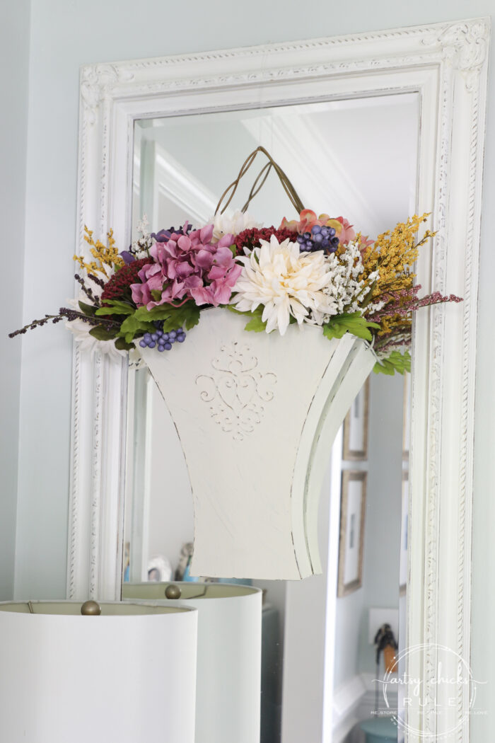 white metal bucket on mirror with colorful fall flowers