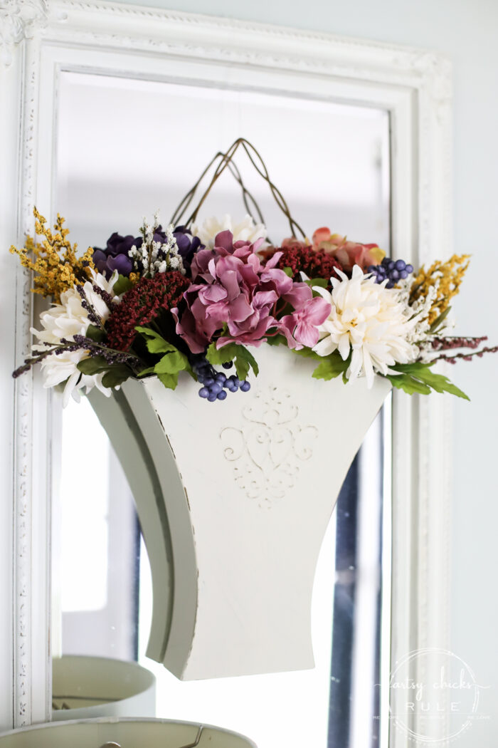 ivory metal hanger on mirror filled with colorful fall flowers