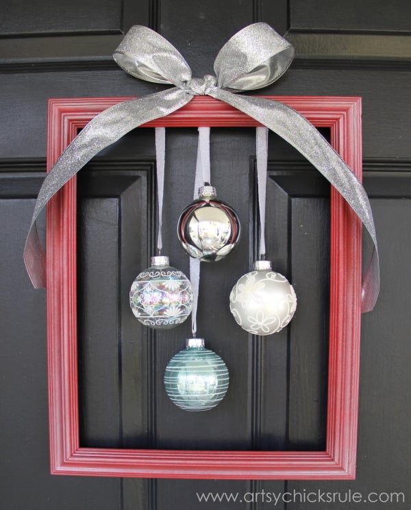 red framed wreath with ornaments hanging