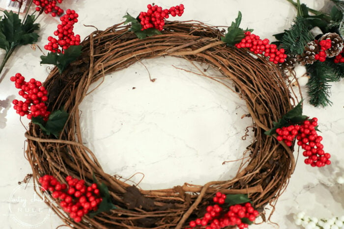 Fun and festive DIY red berry wreath made with items found at the Dollar Store! Budget friendly (and oh so simple) holiday decor! artsychicksrule.com #redberrywreath #diychristmaswreath #dollarstorecrafts #dollarstorewreath