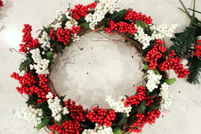 Fun and festive DIY red berry wreath made with items found at the Dollar Store! Budget friendly (and oh so simple) holiday decor! artsychicksrule.com #redberrywreath #diychristmaswreath #dollarstorecrafts #dollarstorewreath