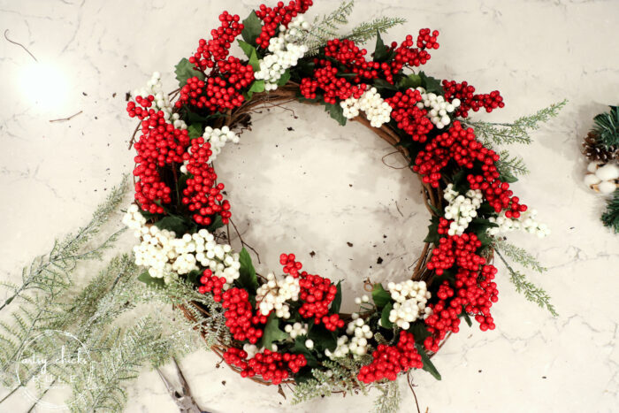 Fun and festive DIY red berry wreath made with items found at the Dollar Store! Budget friendly (and oh so simple) holiday decor! artsychicksrule.com #redberrywreath #diychristmaswreath #dollarstorecrafts #dollarstorewreath