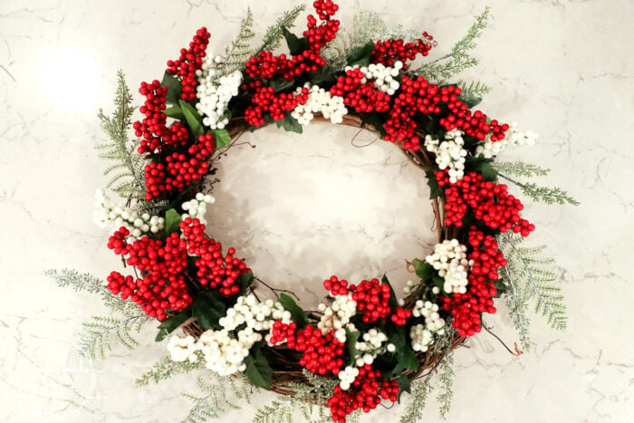 Fun and festive DIY red berry wreath made with items found at the Dollar Store! Budget friendly (and oh so simple) holiday decor! artsychicksrule.com #redberrywreath #diychristmaswreath #dollarstorecrafts #dollarstorewreath