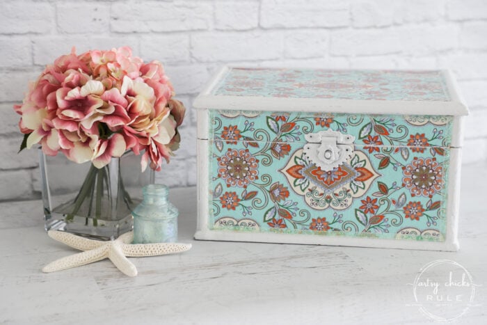 teal tissue paper covered box with pink flowers in vase