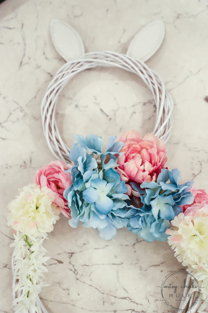 This adorable pink & blue bunny wreath is simple to throw together with just a few items! Perfect for spring and a fun project for kids! artsychicksrule.com #bunnywreath #pinkandbluewreath #springwreath #bunnyprojects