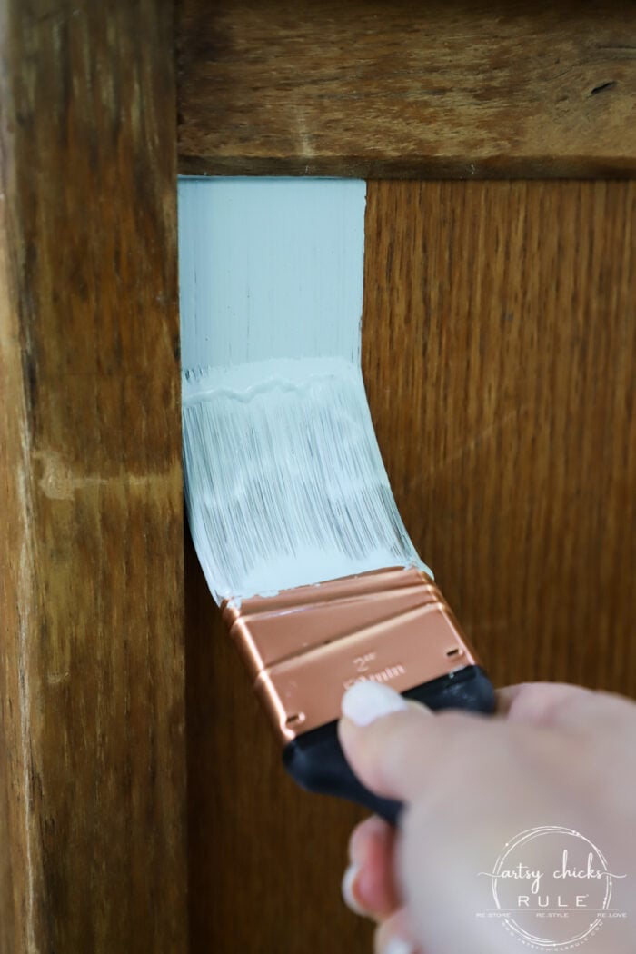 aqua paint on a paintbrush brushing furniture