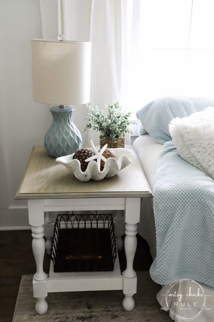 side table finished with shell bowl and blue lamp