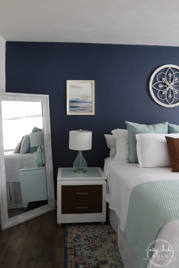 Abstract beach art on navy bedroom wall