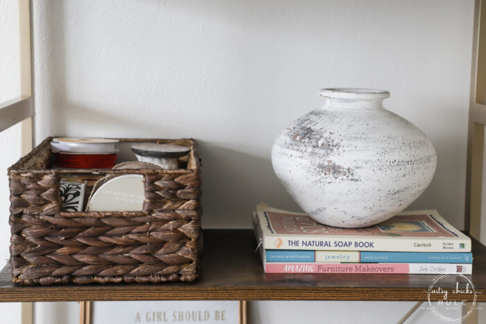 white pottery on books with basket filled with ribbon