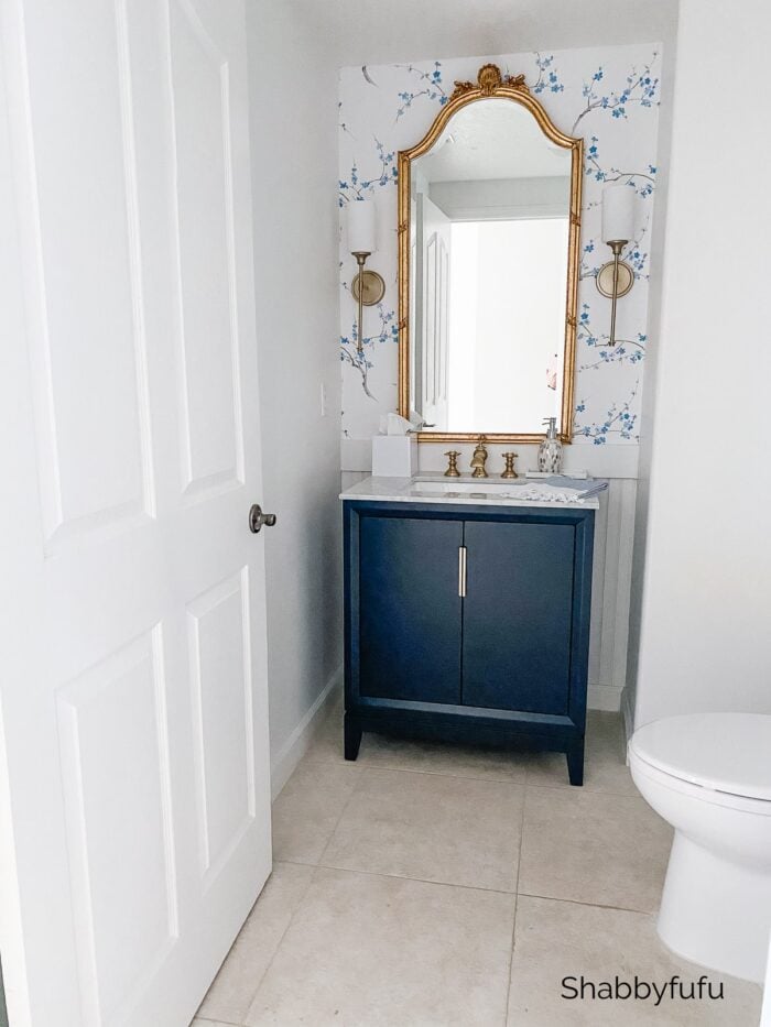 dark blue bath cabinet with blue floral wallpaper