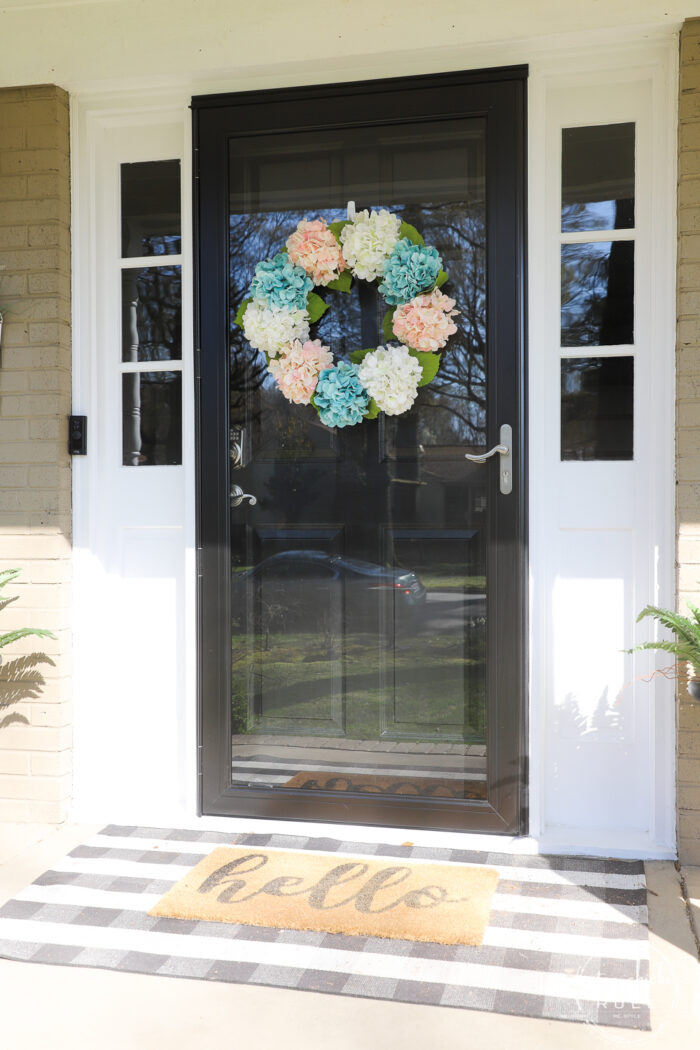 exterior black storm door with pink and aqua hyrdranga wreath
