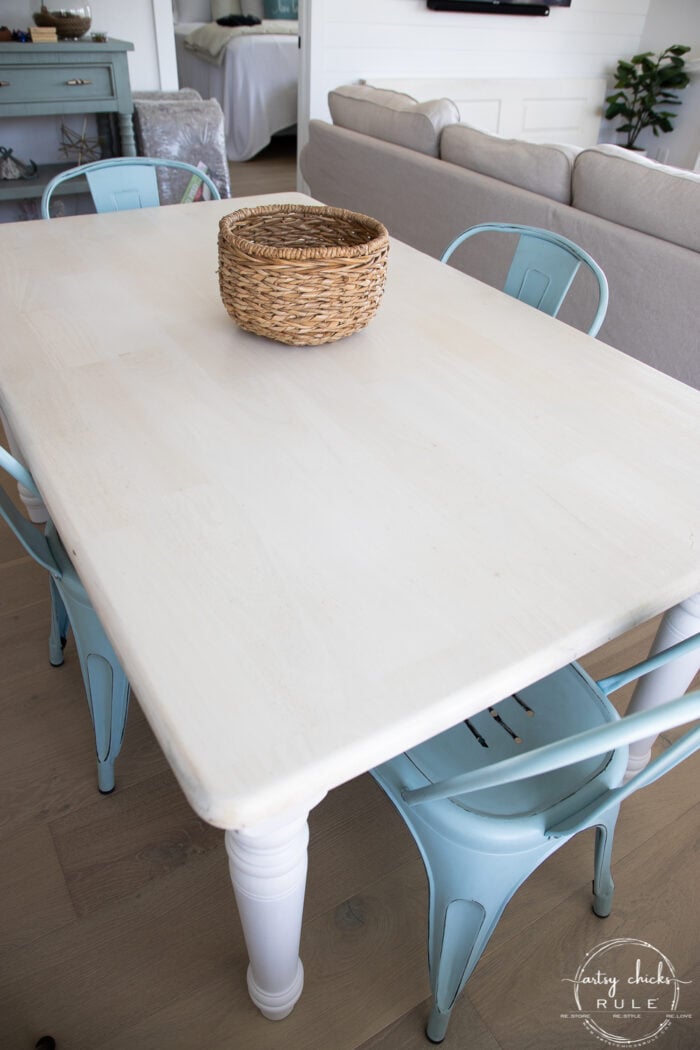 bleached tabletop with basket and blue chairs