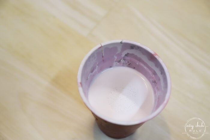 red solo cup with watered white paint on wood table