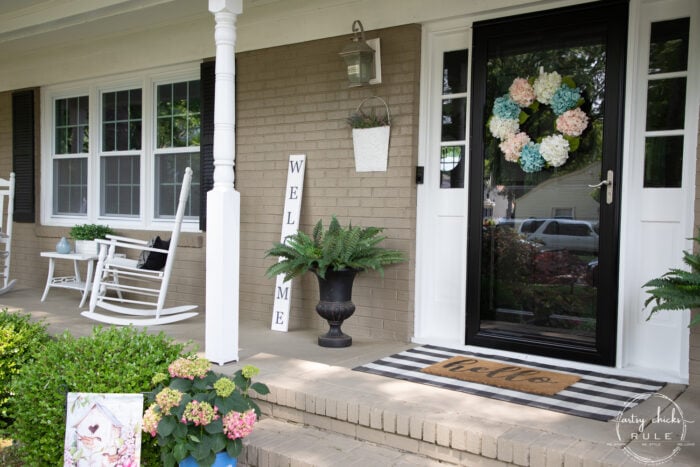 black and white front porch with white rockers and welcome sign