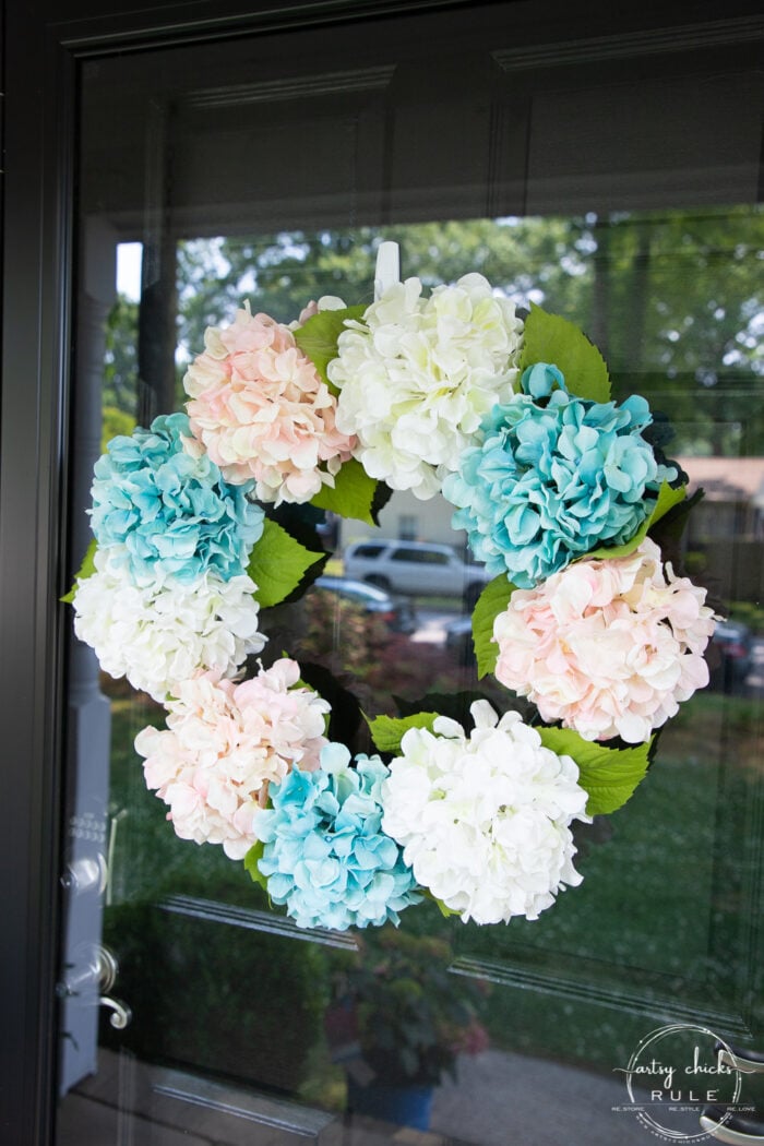 pink, white and teal hydrangea wreath on glass door