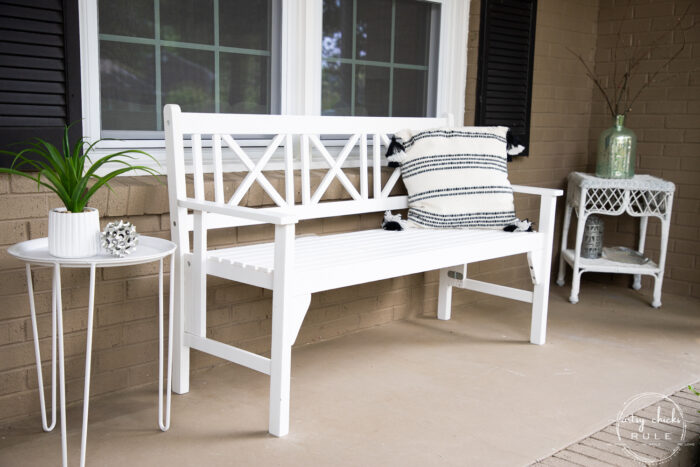 white bench, black shutters and black and white pillow