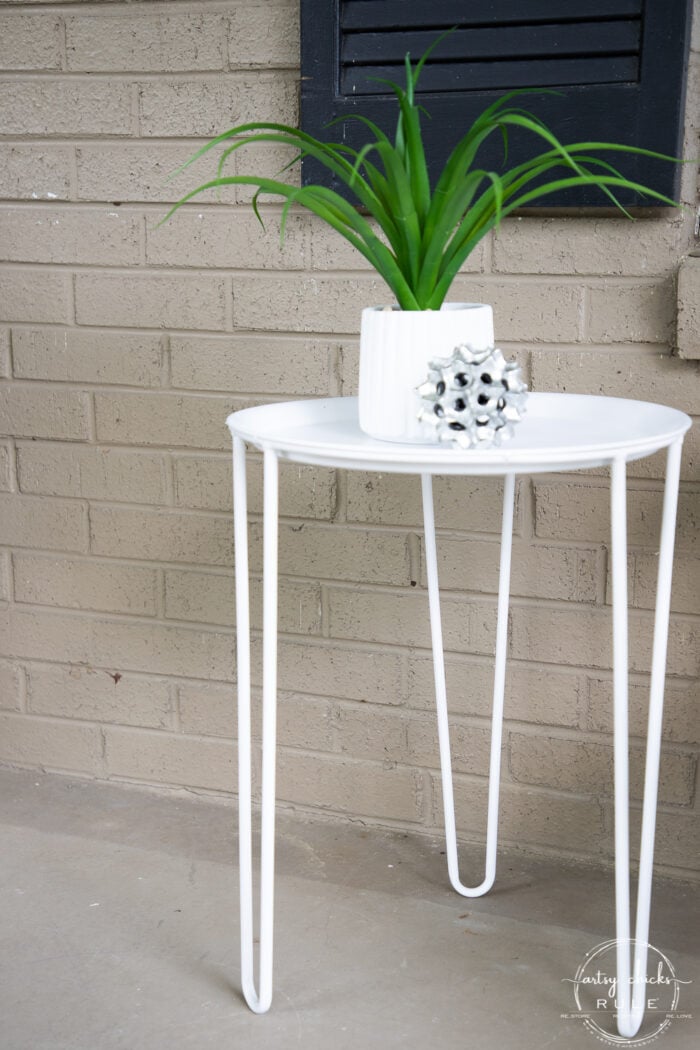 white metal table with green plant and silver decor