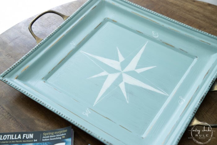 sideview of aqua tray with white compass rose up close