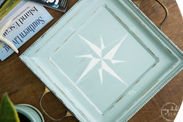 top view of blue tray with white compass rose on wood table