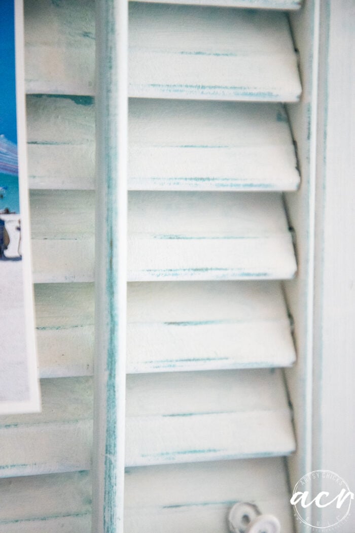 distressed white shutters with aqua up close