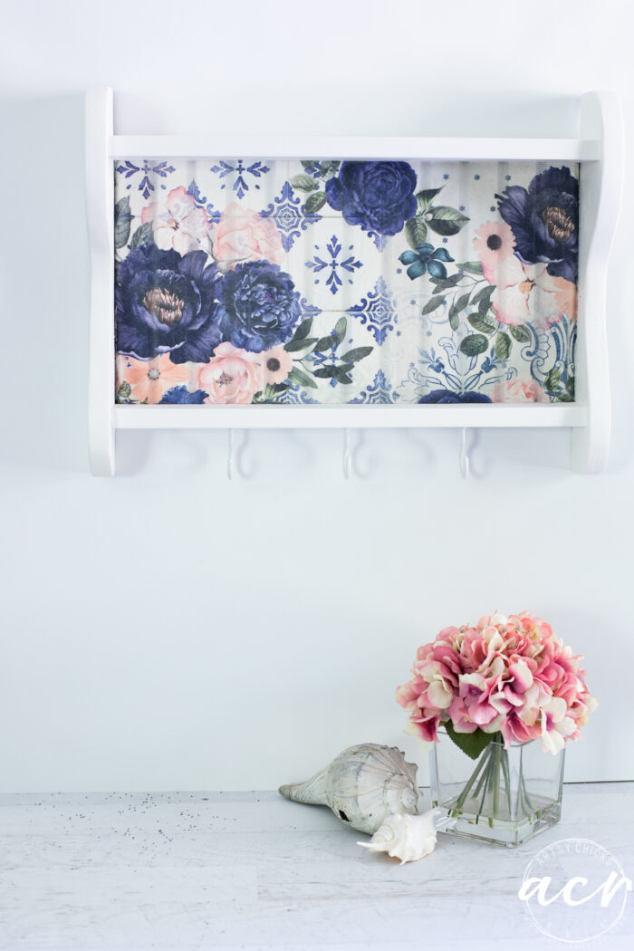 white shelf with blue flowers hanging on wall 