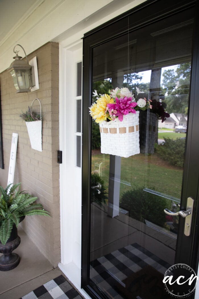 black and white porch with colorful basket on door